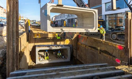 Met een mobiele telescoopkraan van 80 ton worden iedere werkdag drie rioleringskokers geplaatst.   ©Agentschap Wegen en Verkeer